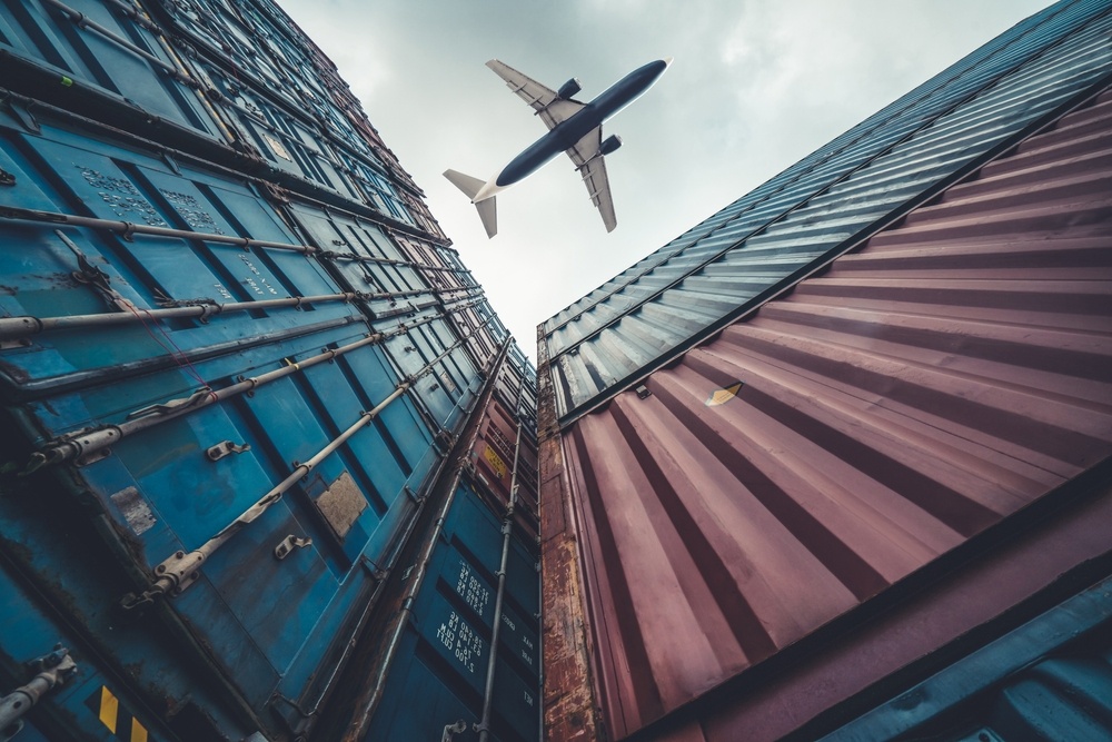 avião voando e containers